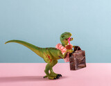Cute dinosaur with flower necklace and vintage suicase drinks coconut water on pink and blue background.