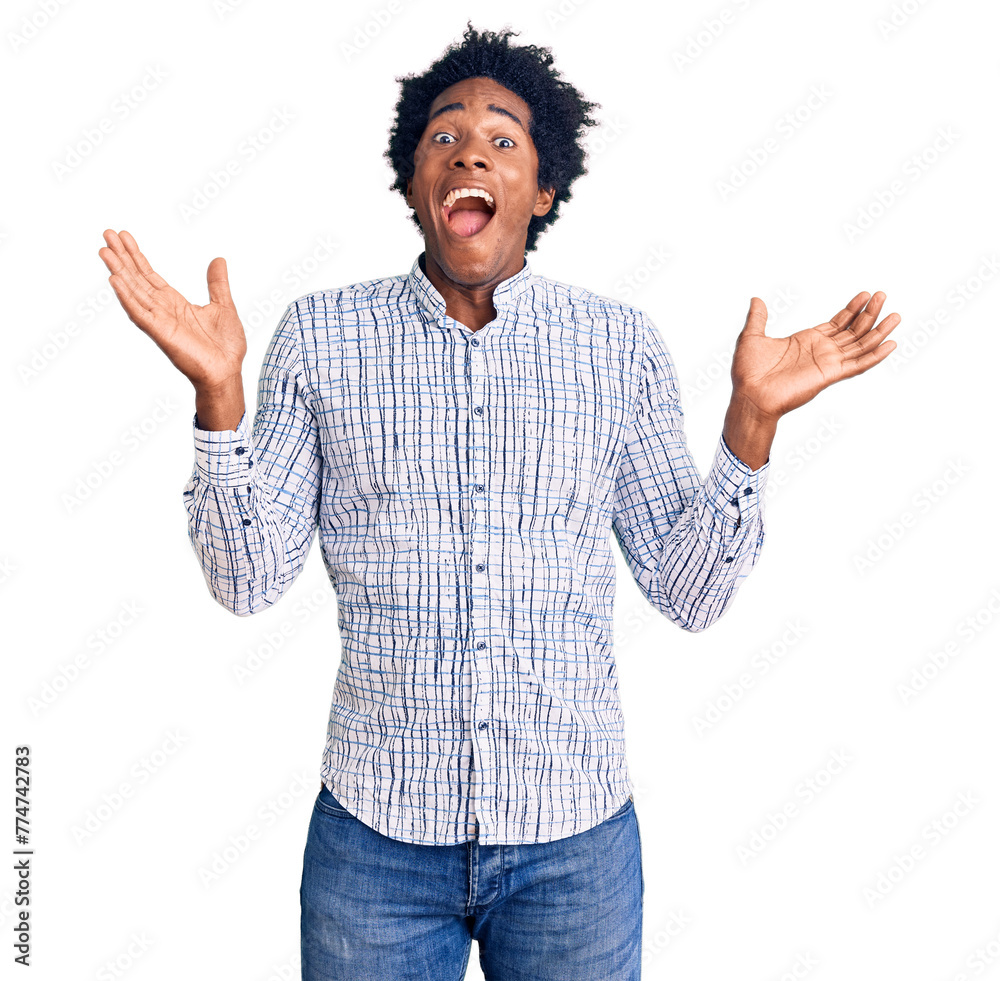 Handsome african american man with afro hair wearing casual clothes celebrating victory with happy smile and winner expression with raised hands Handsome african american man with afro hair wearing casual clothes celebrating victory with happy smile and winner expression with raised hands