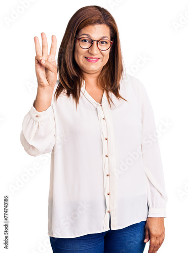 Middle age latin woman wearing casual clothes and glasses showing and pointing up with fingers number three while smiling confident and happy.