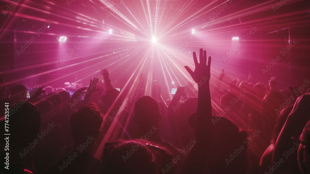 Crowd of people are at concert, with person in front of crowd holding their hand up. Atmosphere is energetic and lively, with everyone enjoying music and performance.