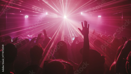 Crowd of people are at concert, with person in front of crowd holding their hand up. Atmosphere is energetic and lively, with everyone enjoying music and performance.