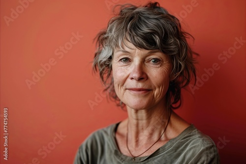 Portrait of a senior woman with grey hair on a red background