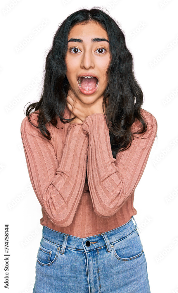 Obraz premium Hispanic teenager girl with dental braces wearing casual clothes shouting and suffocate because painful strangle. health problem. asphyxiate and suicide concept.