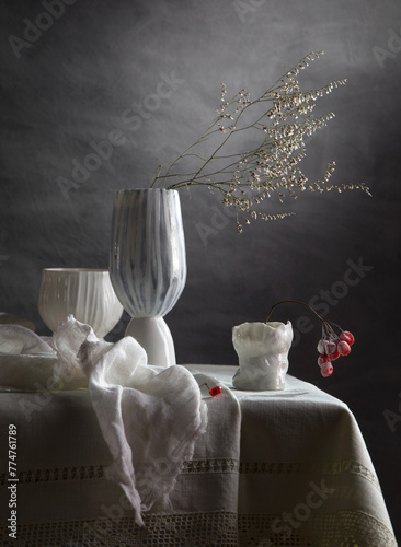 Modern still life with a dry branch in a porcelain vase on a dark background