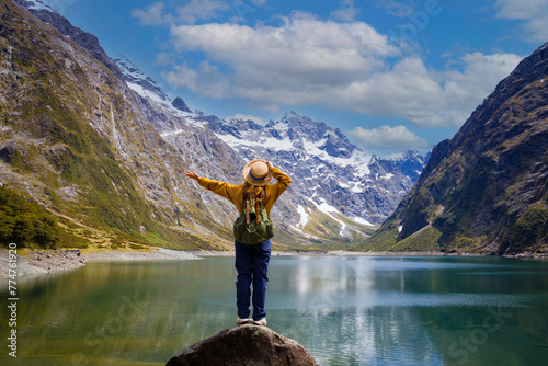 Happy young woman  look on the mountain landscape. Travel and active life concept  as Adventure travel in the mountains region in lake marian  fiordland national park photo