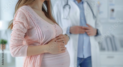 Close-up of pregnant woman's belly in clinic and doctor. Blurred background.