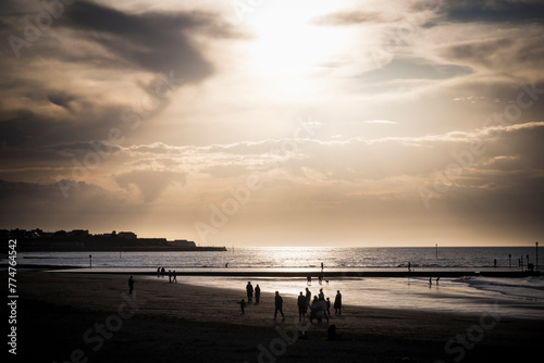 Silhouetted holidaymakers on Margate beach in Kent