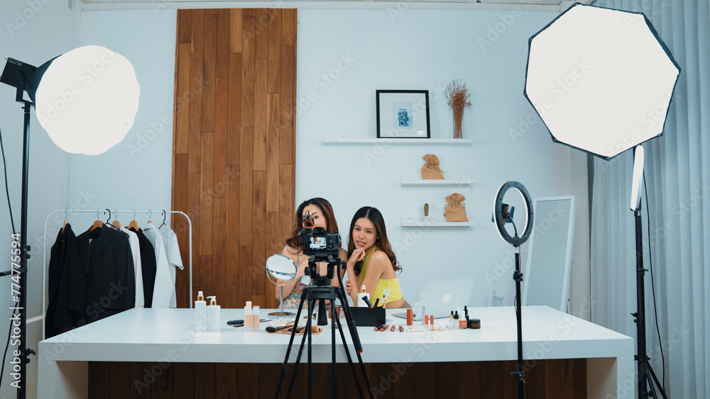Two influencer partner shoot live streaming vlog video review makeup social media or blog. Happy young girl with vivancy cosmetics studio lighting for marketing recording session broadcasting online. - obrazy, fototapety, plakaty 