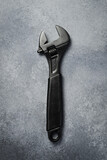 The concept of repair of equipment. adjustable spanner (monkey spanner) on a gray concrete table. Top view.