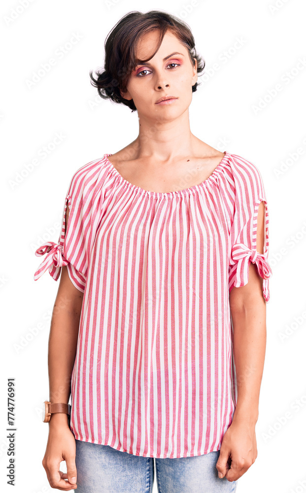 Beautiful young woman with short hair wearing casual summer clothes relaxed with serious expression on face. simple and natural looking at the camera. Beautiful young woman with short hair wearing casual summer clothes relaxed with serious expression on face. simple and natural looking at the camera.