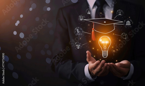 A businessman holds a light bulb with a graduation hat and glowing icons representing education, knowledge sharing, or online learning on a black background, in the style of a training course