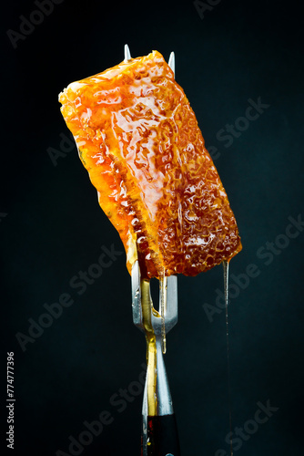 Honeycombs on a metal fork. Macro photo. Organic honey.