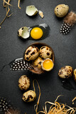 Close-up of quail egg yolk and quail fresh eggs. On a black stone background. Top view.
