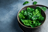 Fresh green spinach in a ceramic plate. Healthy food concept. Space for text.