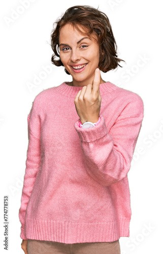 Young hispanic woman wearing casual clothes beckoning come here gesture with hand inviting welcoming happy and smiling