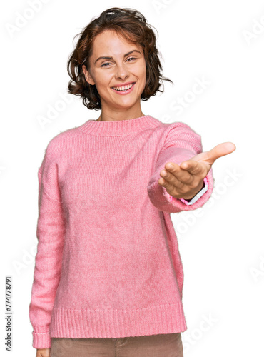 Young hispanic woman wearing casual clothes smiling cheerful offering palm hand giving assistance and acceptance.
