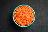 Close-up of lentils in a ceramic bowl. On a dark concrete background.