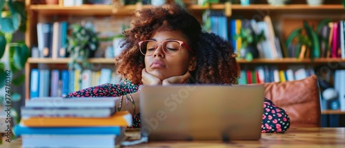 Woman working at office desk with laptop, her eyes are closing and she is about to fall asleep. Sleep deprivation and overtime working concept. photo