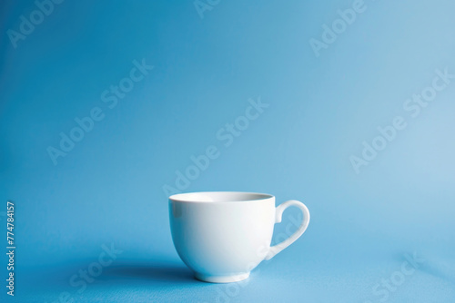A single white coffee cup against a solid blue background