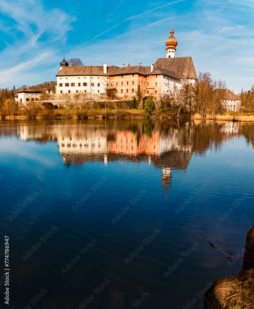 High resolution stitched alpine winter panorama of a monastery with reflections on a sunny winter day at Lake Hoeglwoerther See, Anger, Berchtesgadener Land, Bavaria, Germany