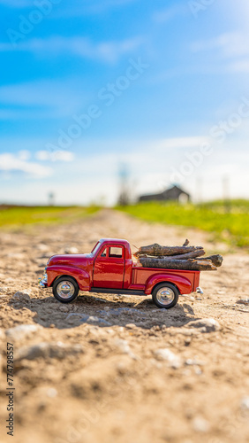 Red retro car carry wood on old road © brankospejs
