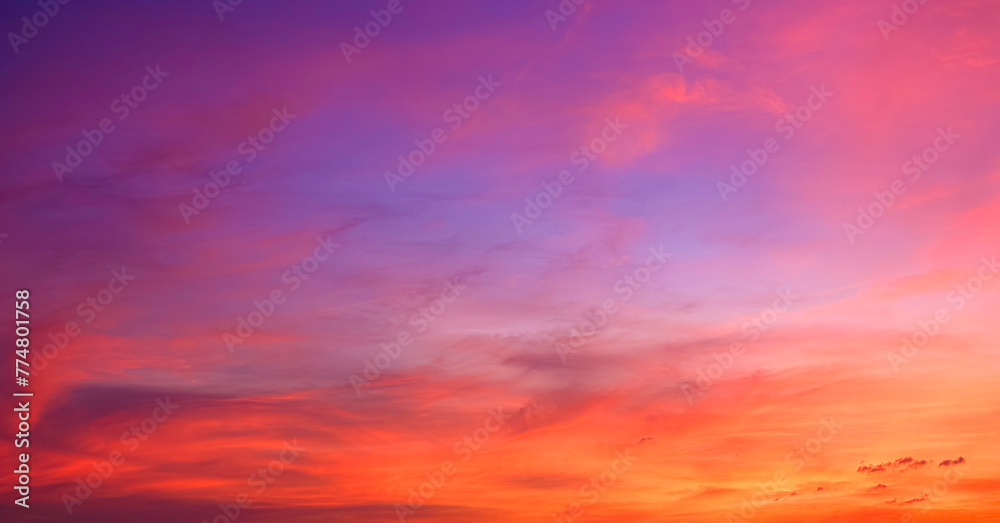 Sunset sky background in the evening with colorful orange, pink, red, yellow sunlight and dramatic sunrise clouds on beautiful amazing twilight horizon sky 