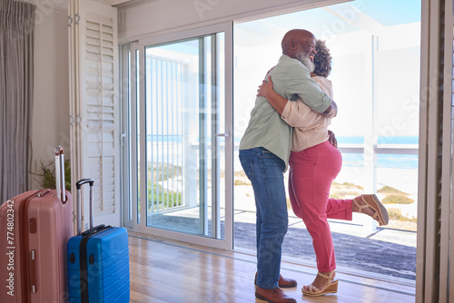 Loving Mature Couple With Luggage Arriving In Beachfront House Overlooking Ocean For Summer Vacation © Monkey Business