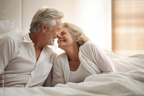 An elderly man and woman in a bed, embracing each other lovingly