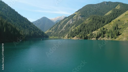 Aerial view of Kolsay Lake, Kulsa National Park, Kazakhstan. Cinematic low altitude forward drone shot of the turquoise lake. Famous landmark touristic destination in Central Asia mountains photo