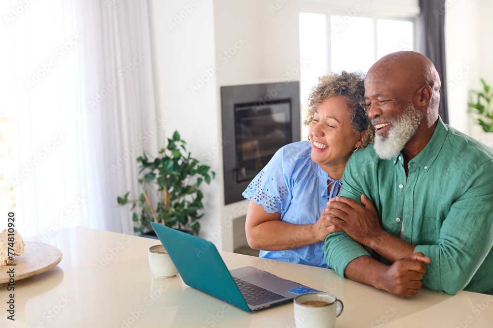Mature Couple At Home With Laptop Making Video Call To Family Or Friends Mature Couple At Home With Laptop Making Video Call To Family Or Friends