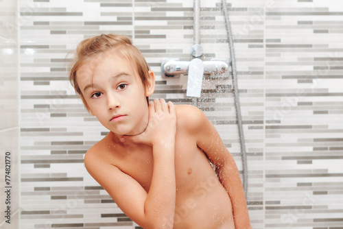 Cute child washing himself in shower.