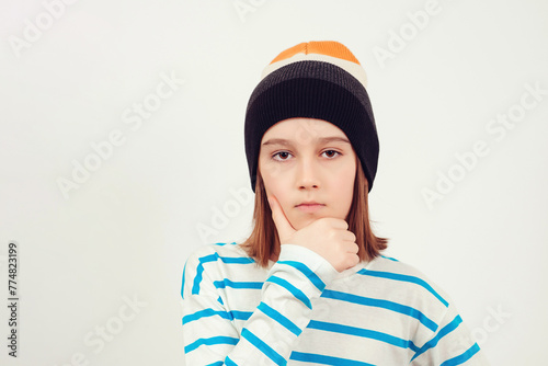 Cute boy thinking over white background. Thoughtful clever schooler. Student with serious expression.