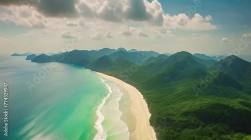 view flying over tropical blue ocean towards beautiful green mountains and white sandy beach
 photo