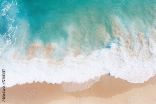 Blue ocean waves on a sandy beach, summer background, top view. 