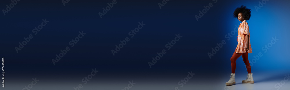 banner of african american model in patterned shirt and orange dress posing on blue backdrop banner of african american model in patterned shirt and orange dress posing on blue backdrop