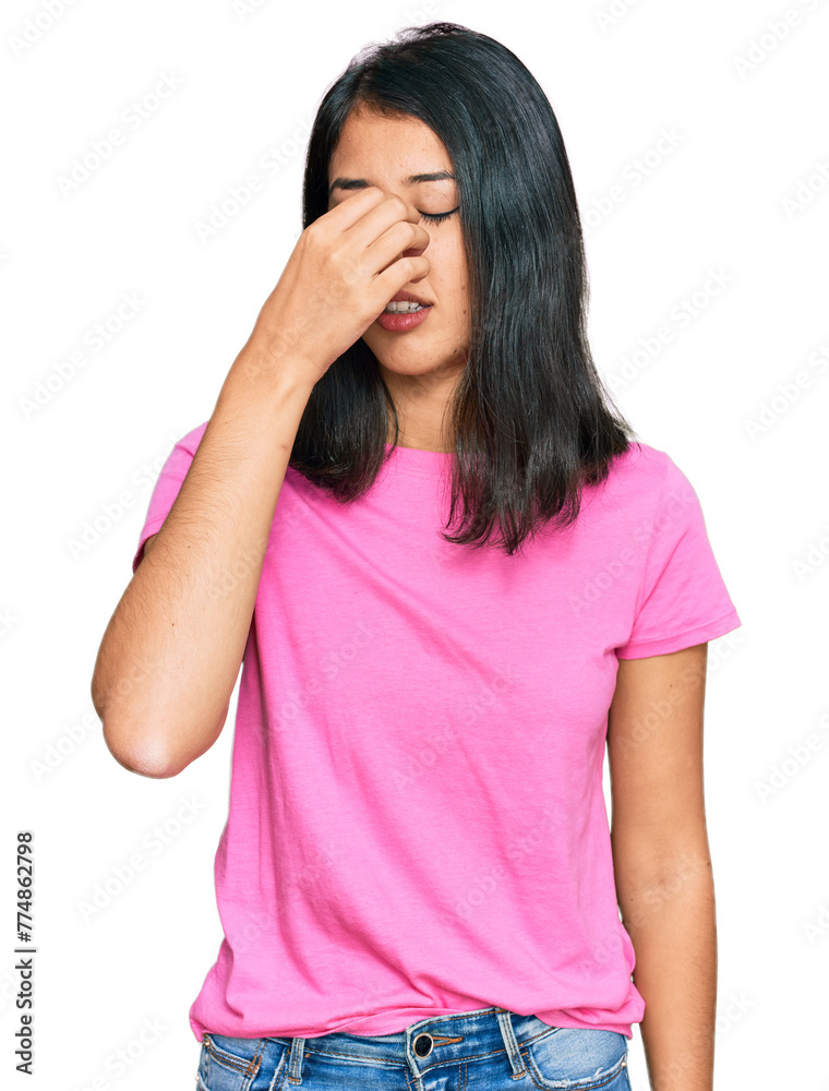 Beautiful asian young woman wearing casual pink t shirt tired rubbing nose and eyes feeling fatigue and headache. stress and frustration concept. Beautiful asian young woman wearing casual pink t shirt tired rubbing nose and eyes feeling fatigue and headache. stress and frustration concept.