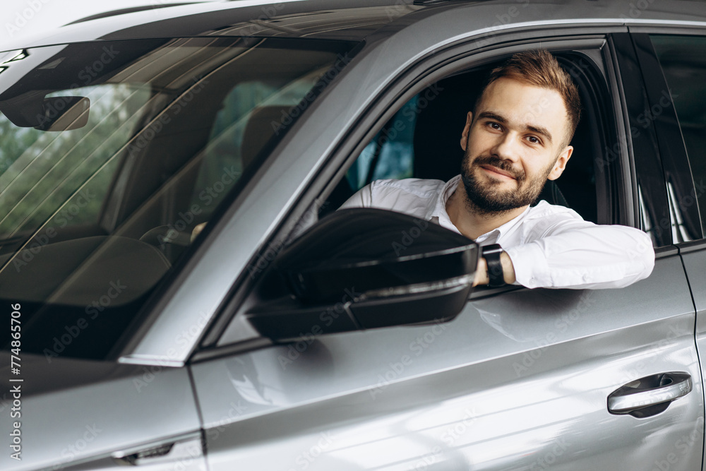 Business man sitting in his new car in car showroom Business man sitting in his new car in car showroom