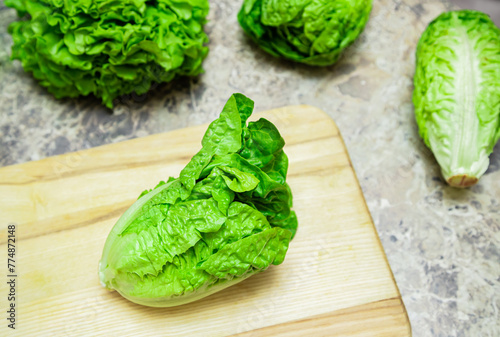 Green romaine lettuce. Baby cos lettuce salad on wooden board kitchen table.Top view	
