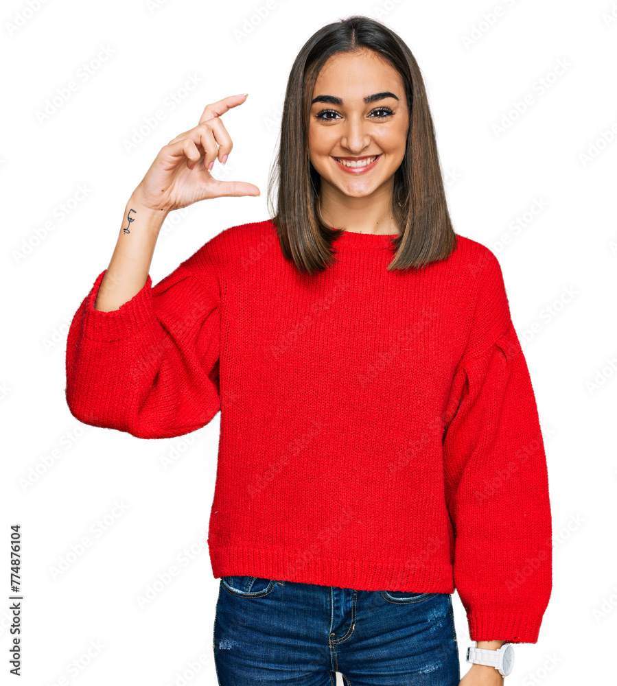 Beautiful brunette woman wearing casual winter sweater smiling and confident gesturing with hand doing small size sign with fingers looking and the camera. measure concept. Beautiful brunette woman wearing casual winter sweater smiling and confident gesturing with hand doing small size sign with fingers looking and the camera. measure concept.