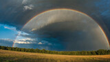 A rainbow arching across the sky after a summer rainstorm.