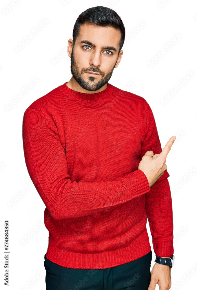 Young hispanic man wearing casual clothes pointing with hand finger to the side showing advertisement, serious and calm face