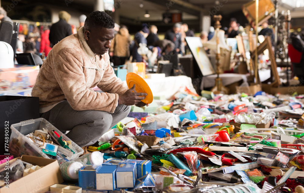 Man African selects antiques at a flea market