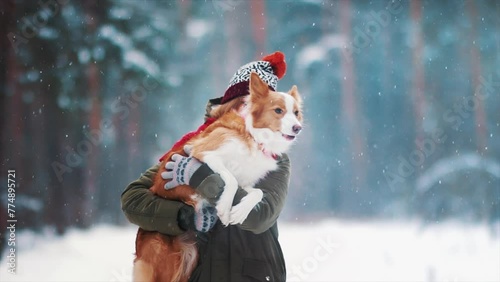 Smiling lady take free time together with her dog. Portrait of woman hug her border collie in winter snowy forest. Love and family concept. Pet lover with her friend. Enjoying vacation in counrtyside photo