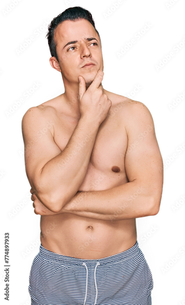 Fototapeta premium Handsome young man wearing swimwear shirtless thinking worried about a question, concerned and nervous with hand on chin