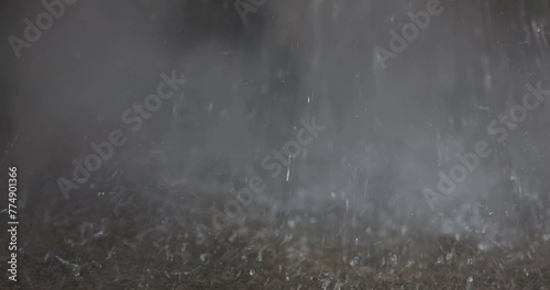 A stream of hot water falls to the floor and evaporates. Close-up of water drops. Waste water droplets fall to the floor, steam from hot falling water photo