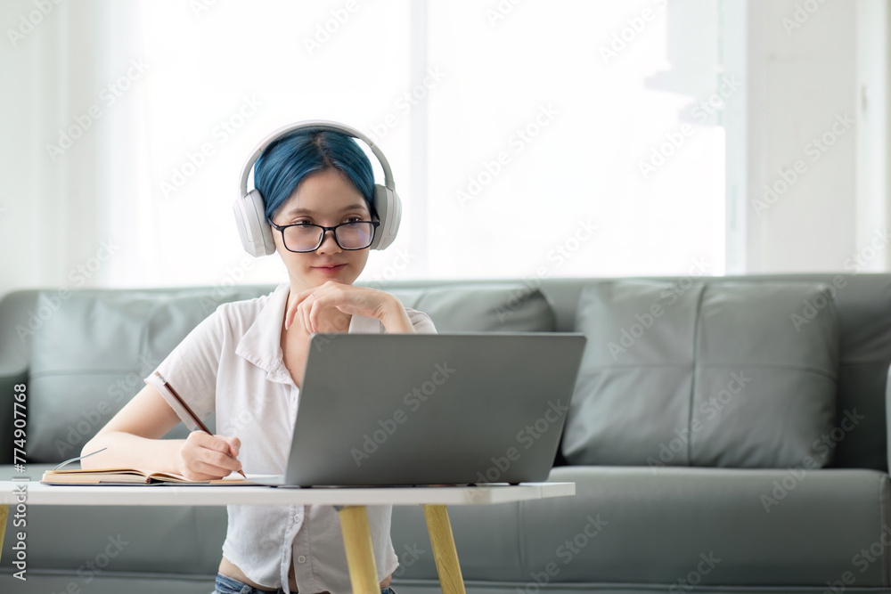 Happy young woman teenage wearing headphones writing note. student online learning class study online video call zoom teacher with laptop and book - obrazy, fototapety, plakaty 