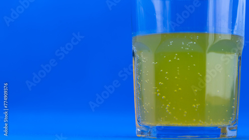 glass with vitamin c on blue background
