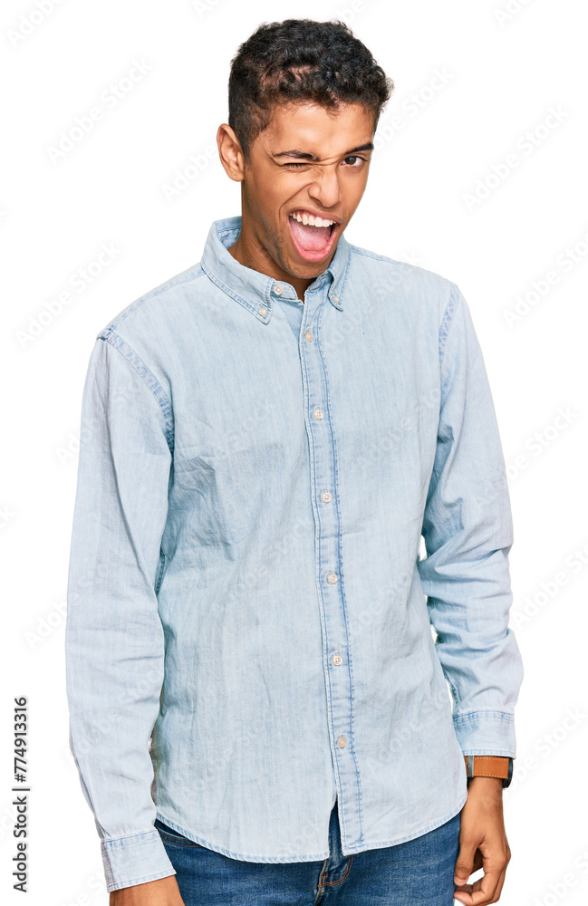 Fototapeta premium Young handsome african american man wearing casual clothes winking looking at the camera with sexy expression, cheerful and happy face.