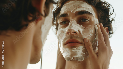 Concentrated man carefully applies a facial mask