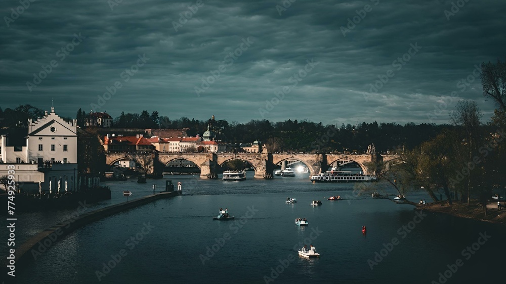 Fototapeta premium a river that is next to a bridge with boats floating in it